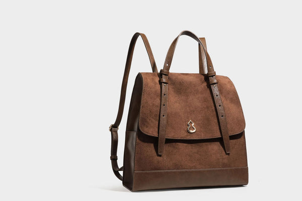 Structured suede-look convertible backpack handbag with flap closure and gold-tone emblem hardware in chocolate brown, detail