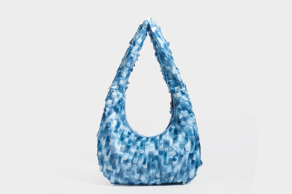 Slouchy crescent hobo shoulder bag covered in overlapping reflective sequin discs with a single integrated strap and top-zip