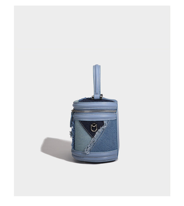 Mini cylindrical barrel bucket bag in denim patchwork with frayed edges, smooth leather-look trim, zip-around top closure