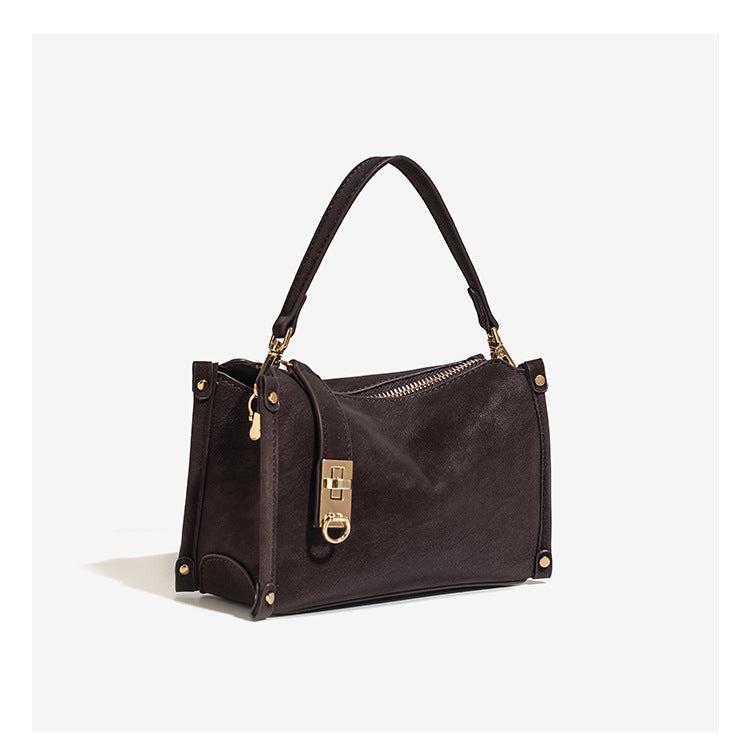 Small structured square handbag in deep dark brown matte pebbled finish with gold-tone turn-lock clasp, top zipper, corner