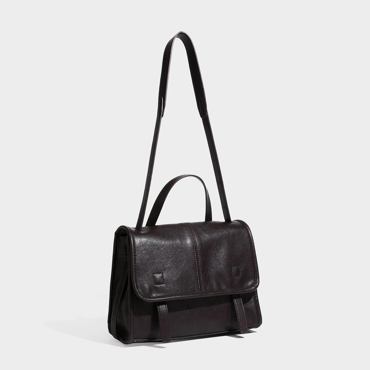 Structured flap satchel bag in dark brown glossy leather-look finish with short top handle and long adjustable shoulder