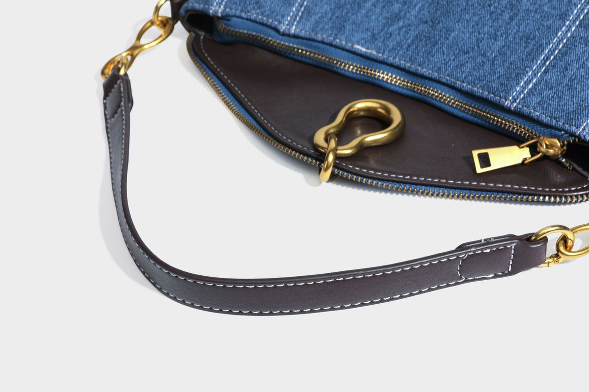 Slouchy denim shoulder bag with dark leather-look trim, gold-tone chain-link hardware, and top zipper closure, detail view 35