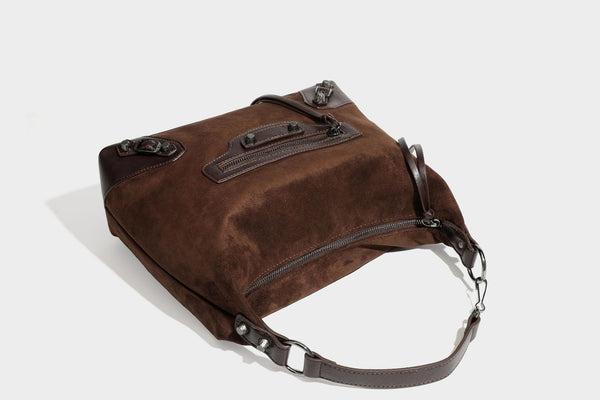 Slouchy suede-finish hobo shoulder bag with dark hardware, exterior zip pocket, tassel ties, and detachable crossbody strap