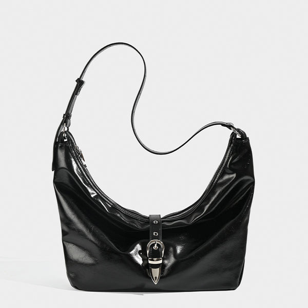 Slouchy crescent hobo bag with glossy leather-look finish, silver-tone buckle hardware, and flat shoulder strap, detail view