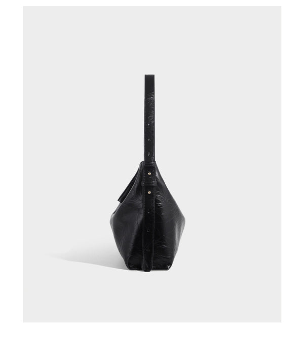 Large slouchy hobo shoulder bag in glossy crinkle leather-look finish with gold-tone emblem hardware and adjustable strap