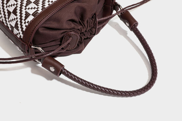 Kleine gewebte Beuteltasche mit geflochtenem Griff in Lederoptik und Kordelzugverschluss, zweifarbiges Muster in Braun und Weiß