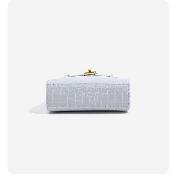 Small structured crocodile-embossed top-handle bag with gold-tone turn-lock closure and detachable shoulder strap, detail