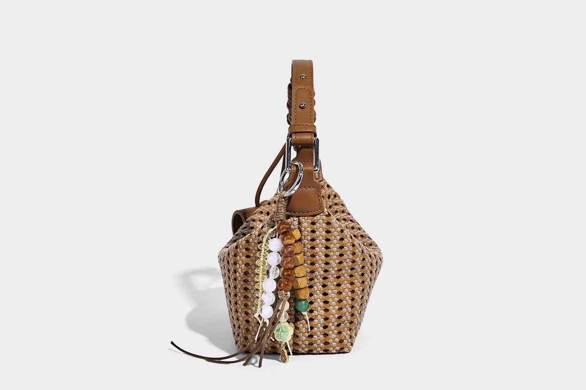 Woven crescent shoulder bag with leather-look knotted handle, zip top, attached mini pouch, and silver-tone hardware, detail