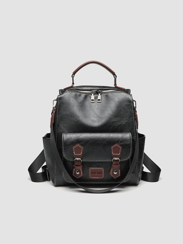 Structured black leather-look convertible backpack handbag with brown contrast trim, buckle front pocket, double-zip top