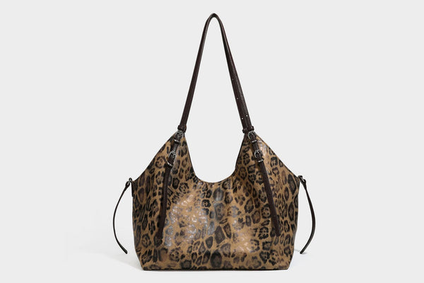 Slouchy leopard-print shoulder tote bag in tan and brown with long double straps, side tie straps, and dangling charm, detail
