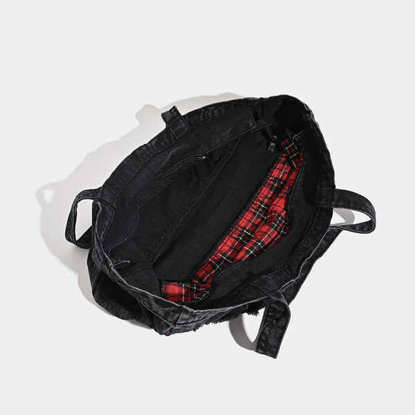 Large washed black distressed denim tote bag with white spider web embroidery and red spider motifs on the front panel