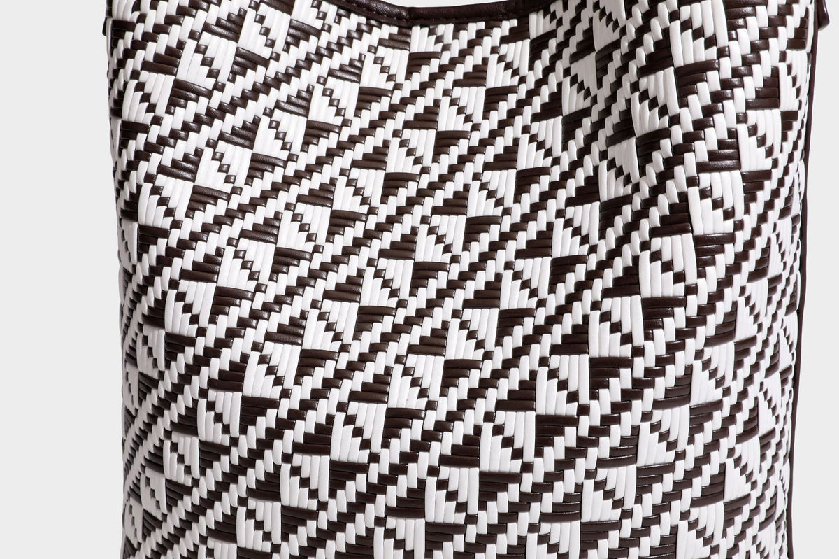 Geflochtene Schultertasche mit geometrischem Ethno-Muster, Besatz in dunkelbrauner Lederoptik, langem verstellbarem Träger und kleinem hängendem Reißverschluss