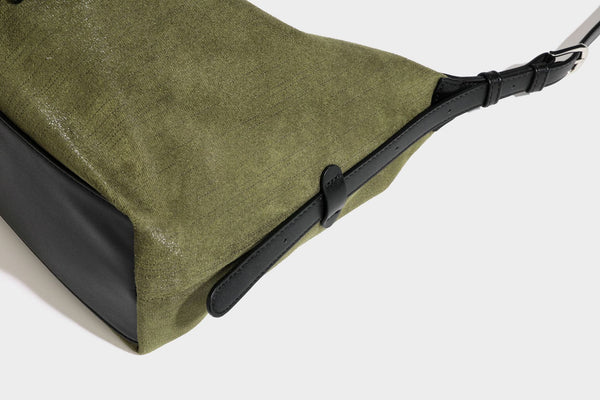 Slouchy olive green canvas hobo shoulder bag with black leather-look trim, zip-top closure, and adjustable strap, detail view
