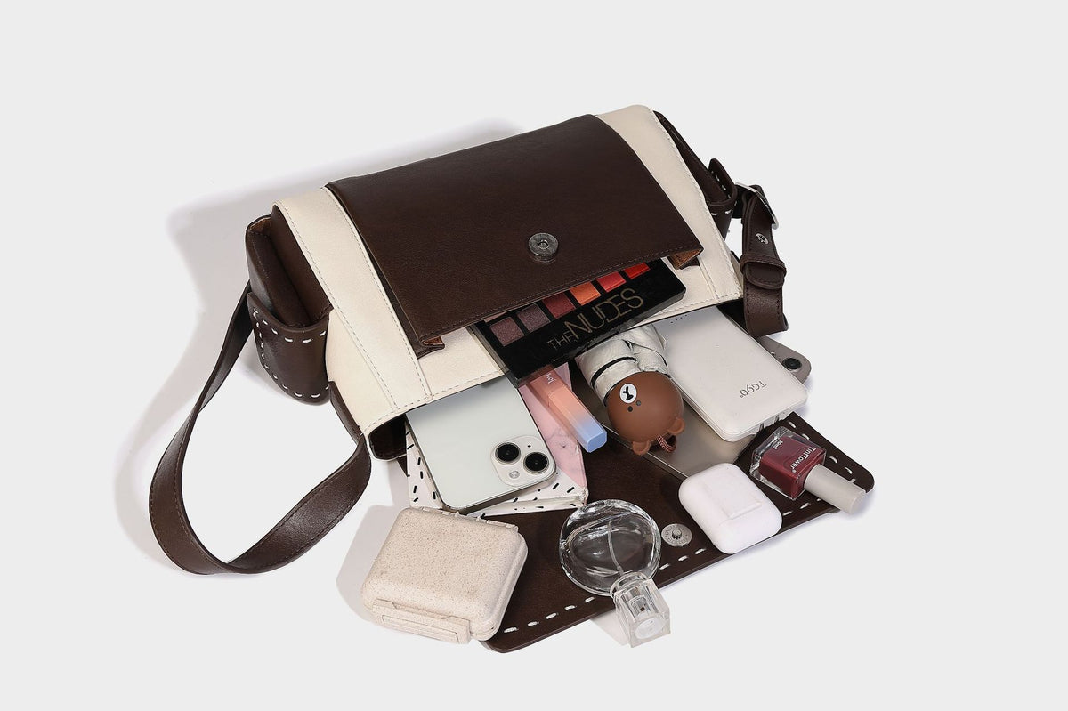 Structured flap crossbody bag in dark brown and cream color-block with white contrast stitching, adjustable shoulder strap