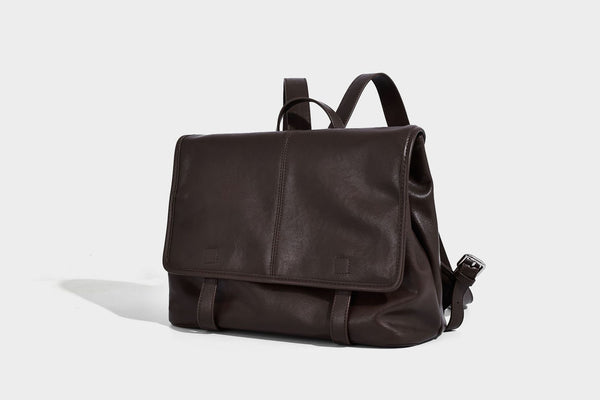Structured tan leather-look flap backpack handbag with top handle, silver buckle hardware, and fold-over front closure