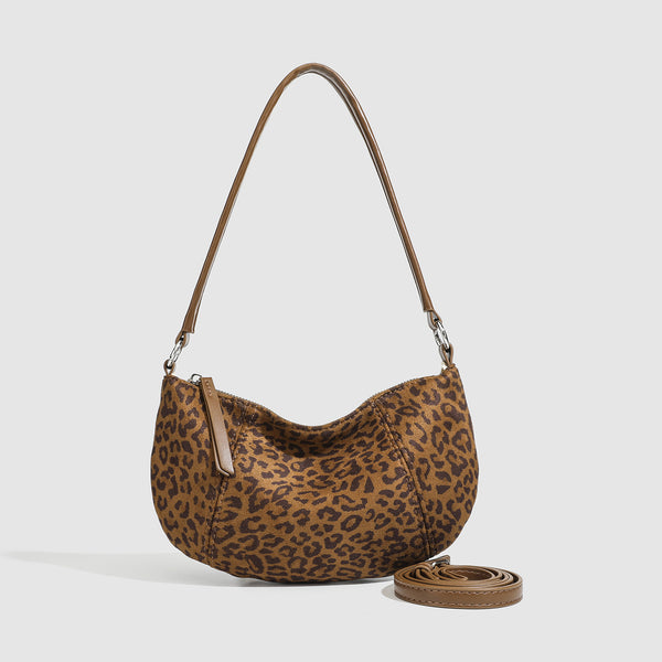 Brown and tan leopard print crescent hobo shoulder bag with zip top closure, front zip pocket, and adjustable silver-tone