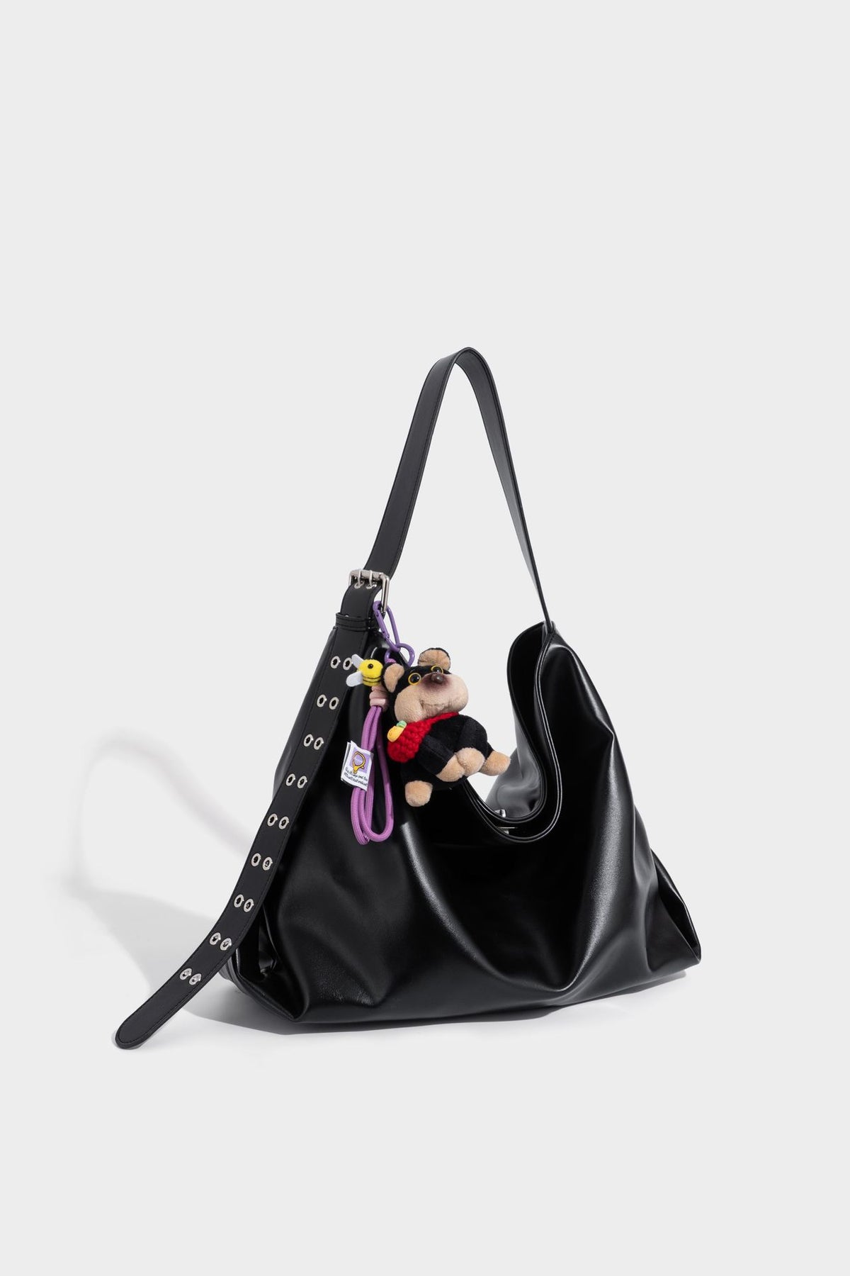 Große schwarze, glänzende Hobo-Schultertasche in Lederoptik mit mit Ösen besetztem Riemen, silberfarbenen Beschlägen und abnehmbarem