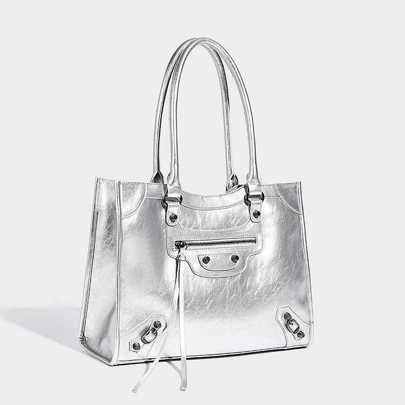 Large structured leather-look tote bag with front zip pocket, moto hardware accents, and long double shoulder straps, detail