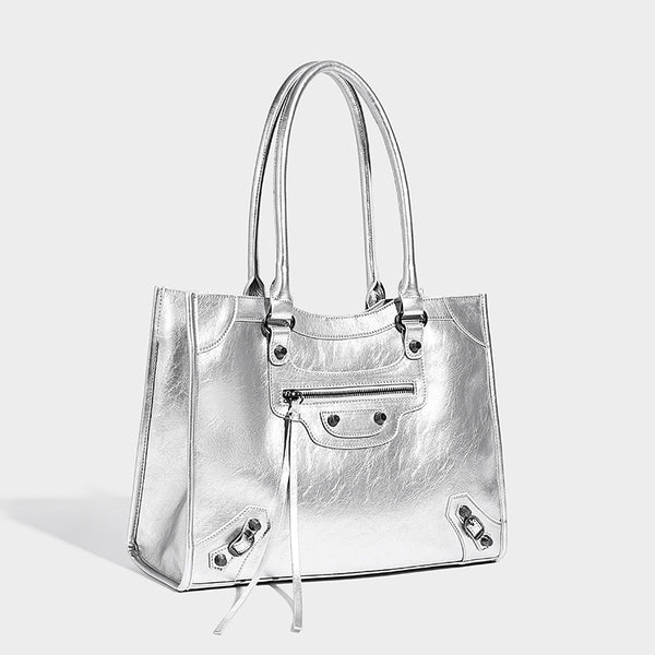 Large structured leather-look tote bag with front zip pocket, moto hardware accents, and long double shoulder straps, detail