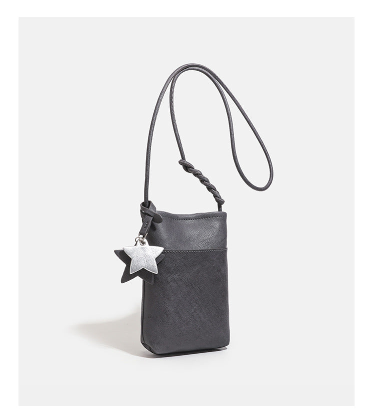 Small vertical textured mini crossbody phone bag with long braided cord strap and silver-toned star charm, detail view 16
