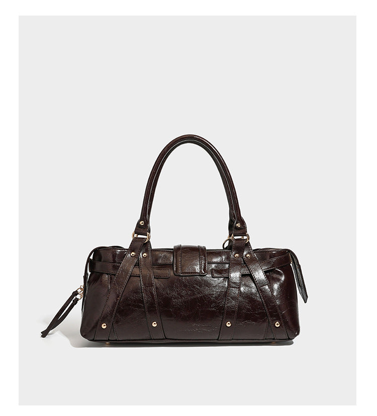 Dark brown glossy crinkled leather-look barrel bag with gold heart lock, dome studs, star charm, dual top handles and, detail