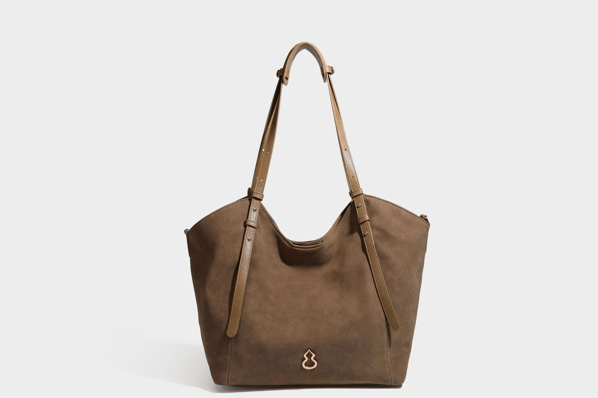 Oversized suede-finish tote shoulder bag in caramel brown with slim leather-look straps and gold-tone logo hardware, detail