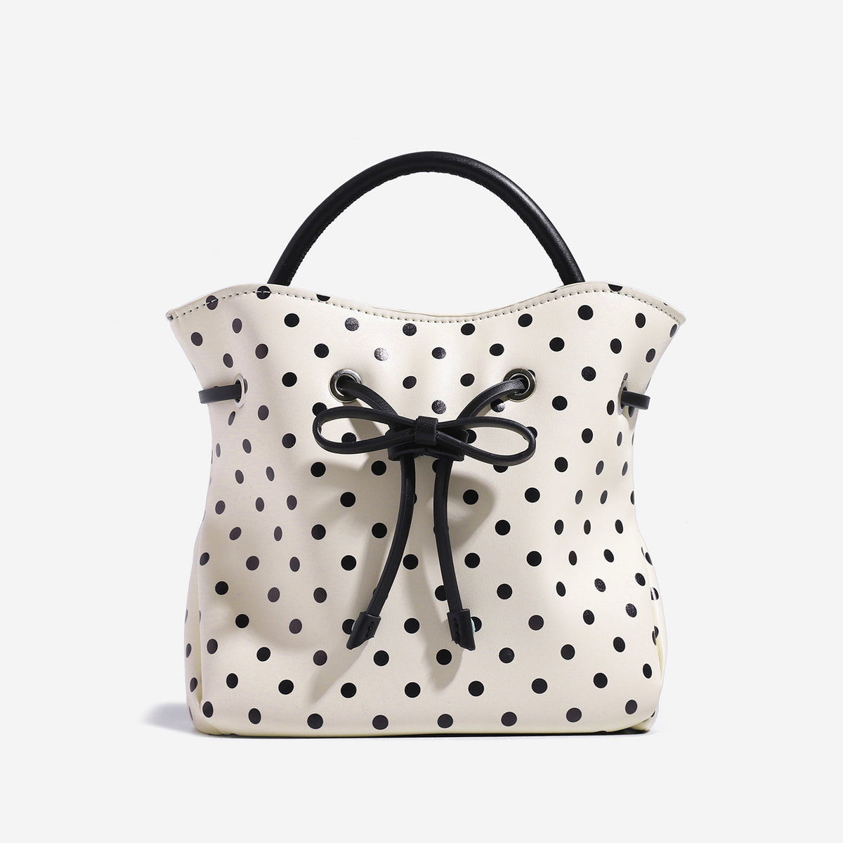 Compact polka-dot drawstring bucket bag with bow closure and rigid top handle, front view