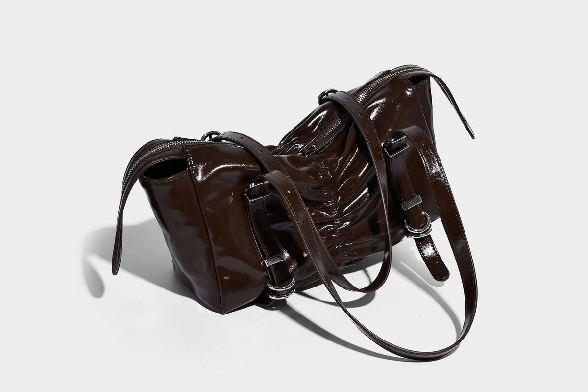 Glänzende, rechteckige Schultertasche mit Raffdetails, zwei verstellbaren Riemen, Reißverschluss oben und Schnallenbeschlägen in Silberoptik