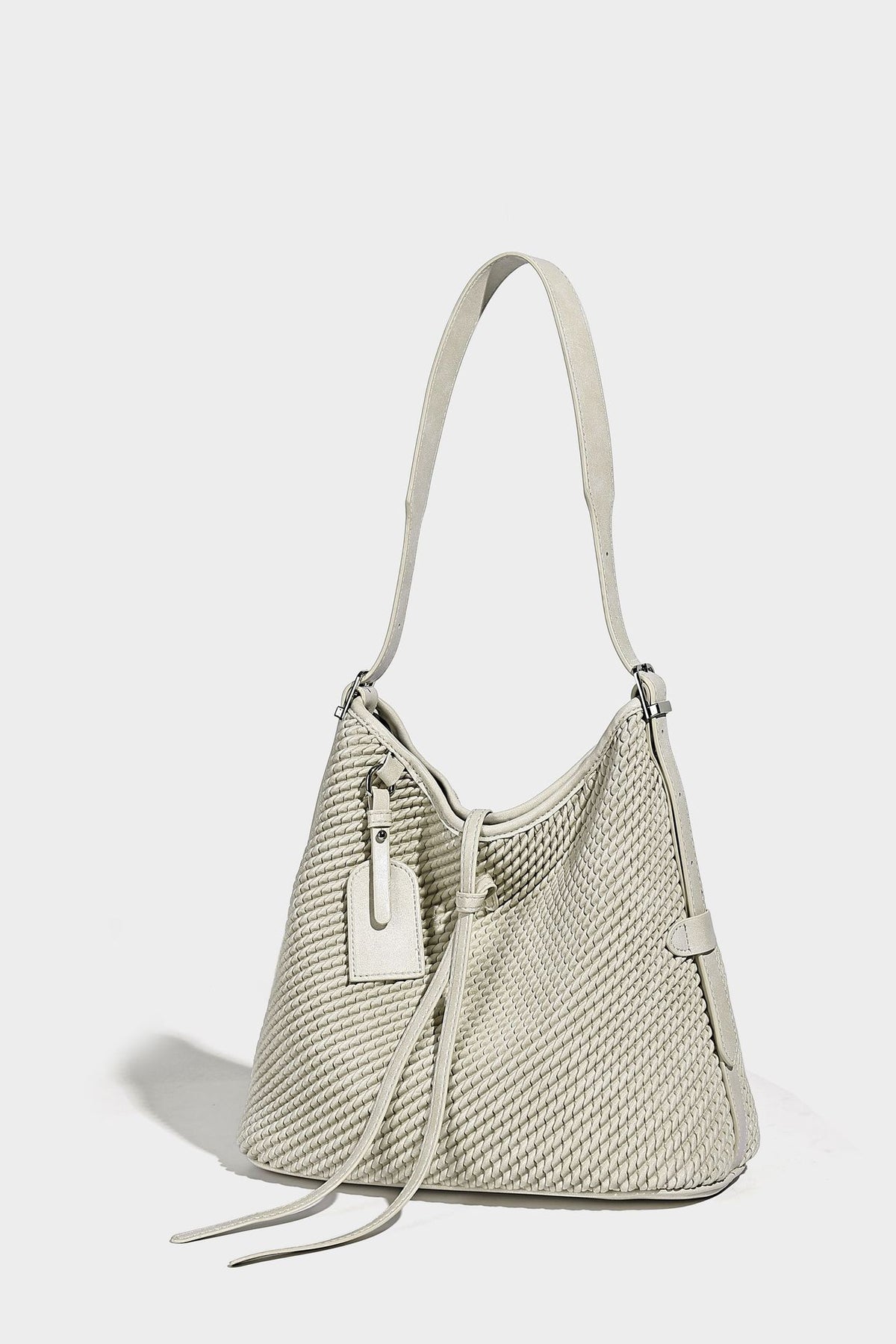 Große Schultertasche im Beuteltaschenstil mit Flechtstruktur, glatten Besätzen in Lederoptik, verstellbarem Riemen und Anhänger-Detail, Detailansicht