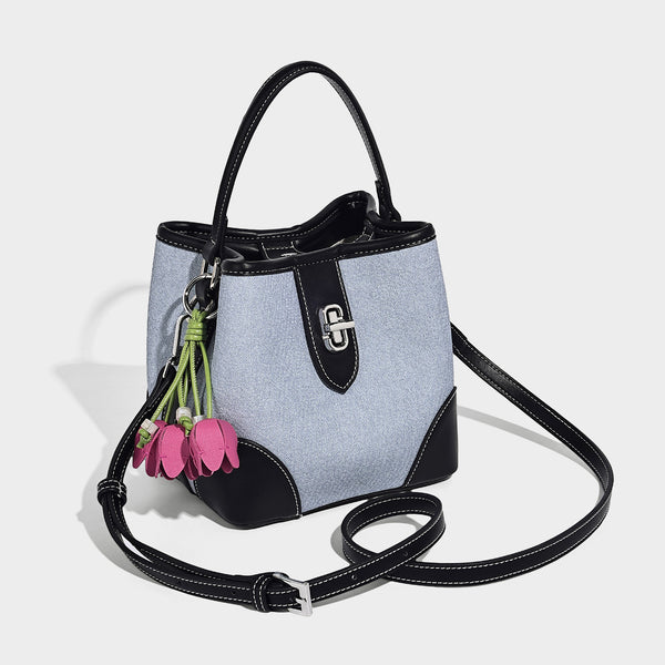 Small structured bucket bag in denim-look light blue fabric with black leather-look trim, silver turn-lock hardware, short