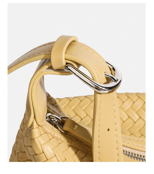 Kompakte gewebte Hobo-Schultertasche mit Reißverschluss oben, silberfarbenem Ringbeschlag und lederähnlicher Außenfläche mit Flechtstruktur, Detail