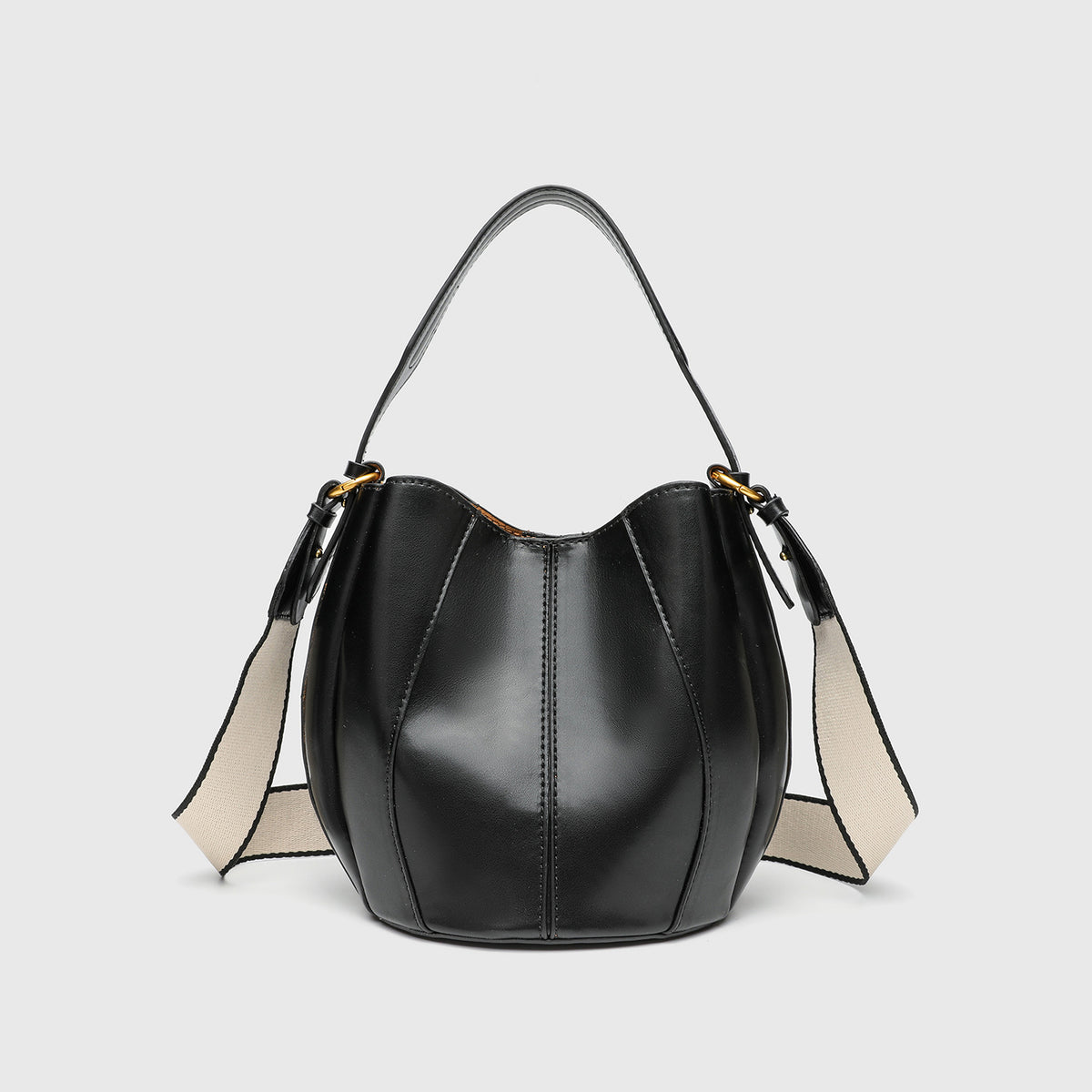 Smooth leather-look paneled bucket bag in brown with wide woven shoulder strap, gold-tone ring hardware, and detachable zip