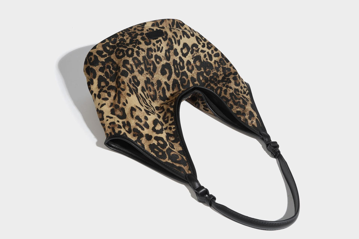 Slouchy brown leopard jacquard hobo tote bag with black leather-look trim and single shoulder strap, shown with black, detail