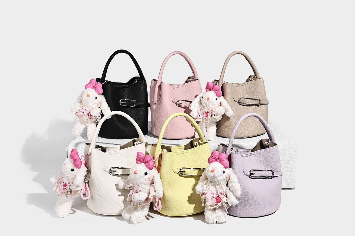Mini pebbled leather-look bucket bag with front buckle strap, silver-tone hardware, top handle, and detachable shoulder