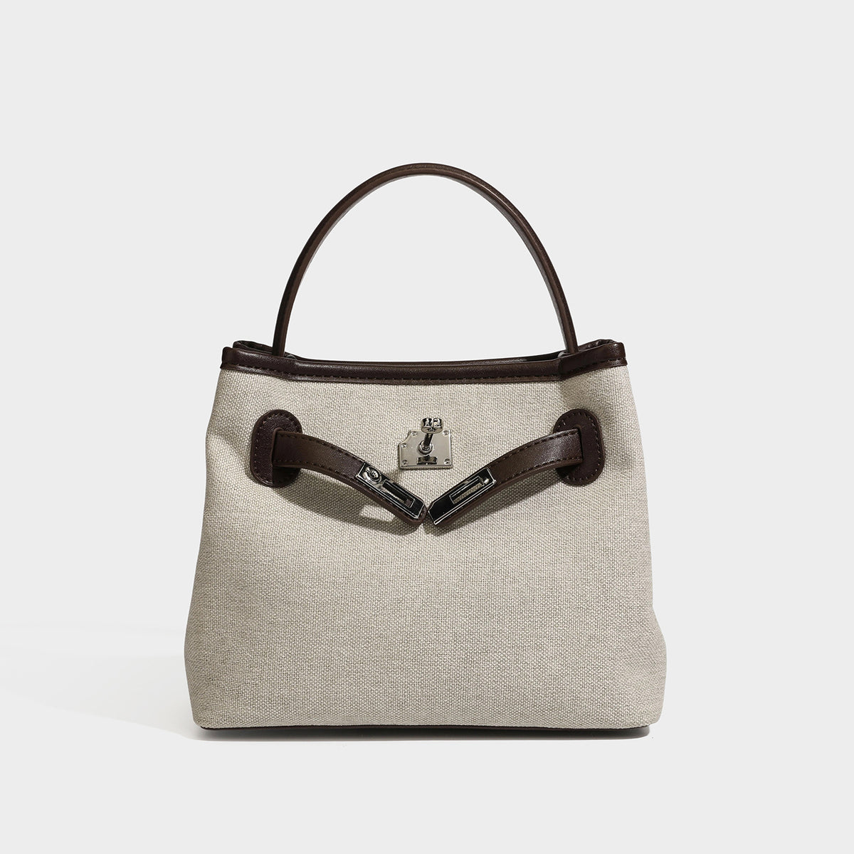 Small structured beige canvas top-handle bag with dark brown leather-look trim, silver turn-lock hardware, and detachable