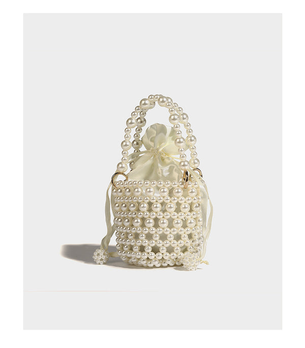 Elfenbeinfarbene Mini-Bucket-Bag aus Kunstperlen mit Satin-Innenbereich und Zugband, goldfarbenen Ringbeschlägen und gewölbtem Perlenhenkel an der Oberseite