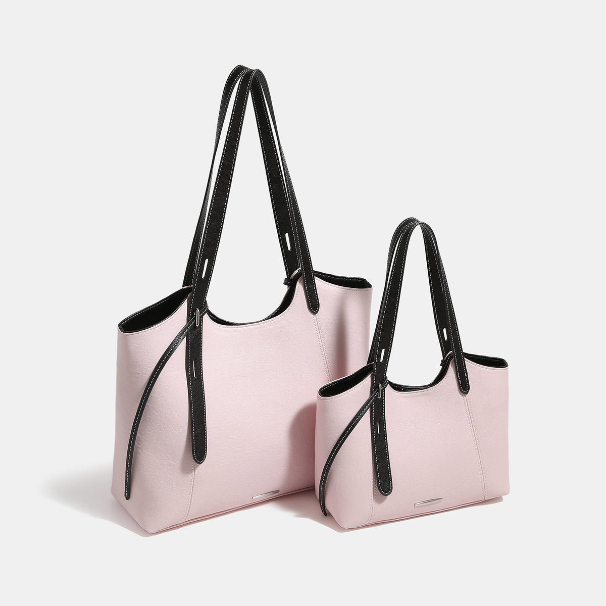 Structured trapezoidal tote bag with smooth leather-look finish, long black contrast shoulder straps, and dangling strap