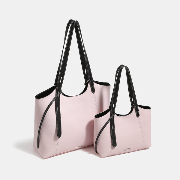 Structured trapezoidal tote bag with smooth leather-look finish, long black contrast shoulder straps, and dangling strap