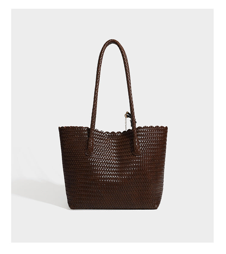 Large open-top woven leather-look tote bag in dark brown with scalloped edge, braided double shoulder straps, and decorative