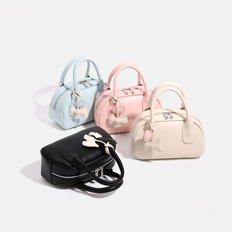 Mini-Handtasche in Kuppelform mit glatter Oberfläche in Lederoptik, zwei Tragegriffen, Reißverschluss oben, Beschlägen in Silberoptik und herabhängendem