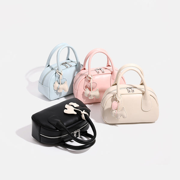 Mini-Handtasche in Kuppelform mit glatter Oberfläche in Lederoptik, zwei Tragegriffen, Reißverschluss oben, Beschlägen in Silberoptik und herabhängendem