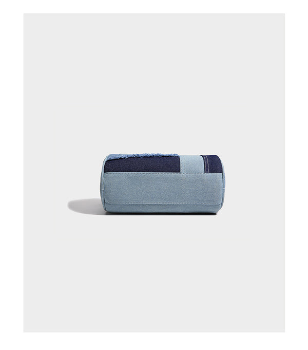 Mini barrel handbag in light and dark denim patchwork with frayed seam trim, dual top handles, top zip closure, and, detail