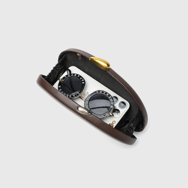 Oval hard-shell crossbody clutch bag with smooth matte leather-look finish and gold-tone snake chain strap, detail view 4