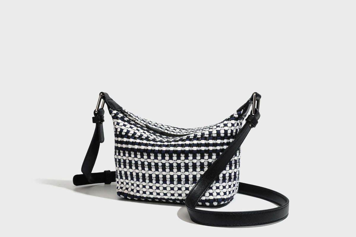 Small crescent shoulder bag in black-and-white woven textile with smooth black leather-look trim, zip-top closure, knotted