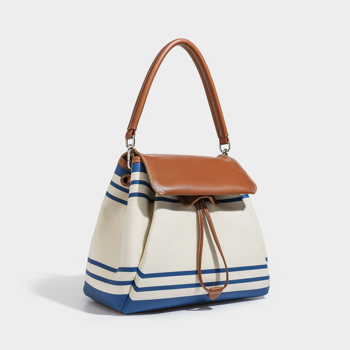 Cream canvas bucket bag with blue horizontal stripes, tan leather-look flap and trim, drawstring closure, silver-tone, front