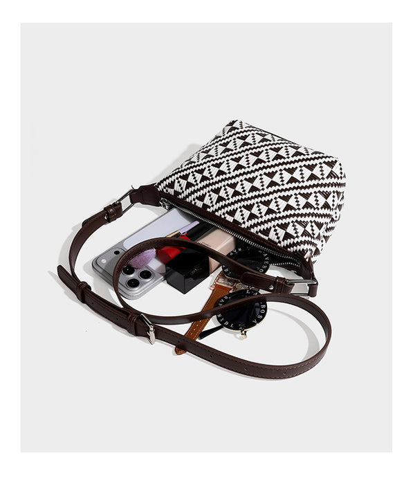 Kleine schwarz-weiße Schultertasche mit gewebtem geometrischem Muster, glatter dunkelbrauner Besatz aus Lederoptik, geknotetem verstellbarem Riemen und seitlichem