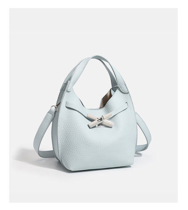 Compact pebbled leather-look shoulder bag with crossed silver-toned metal front closure, short top handle, and long, detail
