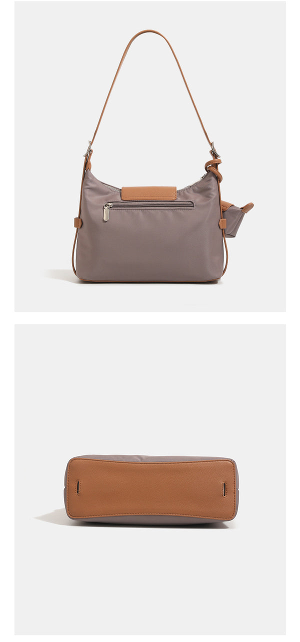 Slouchy hobo shoulder bag in smooth fabric with leather-look tan trim, zip-top closure, adjustable strap, and detachable