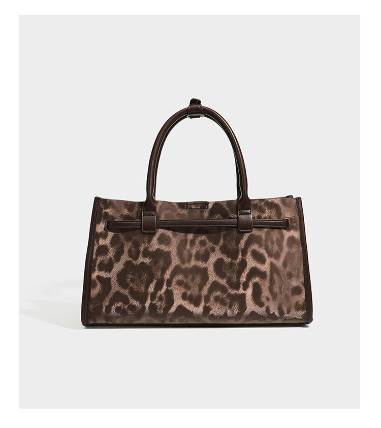 Structured leopard-print tote bag with glossy satin-like finish, dual rounded top handles, silver buckle-and-ring front