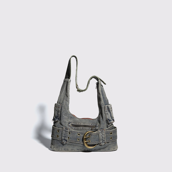 Washed faded denim hobo shoulder bag with wide brass-tone buckle belt panel, eyelet detailing, front zip pocket, and dual
